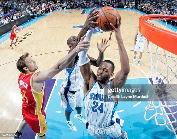 Morris Peterson of the New Orleans Hornets grabs a rebound over David Anderson of the Houston Rockets and Emeka Okafor of the New Orleans Hornets on...