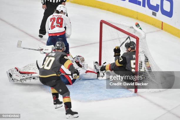 David Perron falls into the net while his teammate Tomas Tatar of the Vegas Golden Knights scores a goal against Braden Holtby and Christian Djoos of...