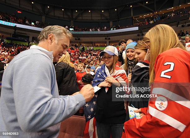 Jim Craig, goalie of the 1980 USA "Miracle on Ice" Olympic gold medalist hockey team signs an USA flag prior to the start of the Men's preliminary...