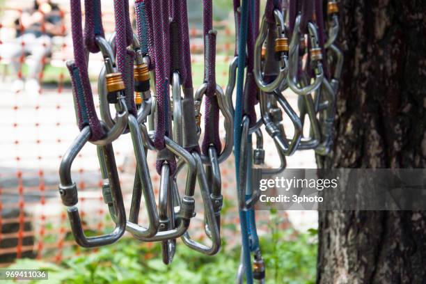 stack of climbing rope carabineers hanging at the playground - carabina fotografías e imágenes de stock