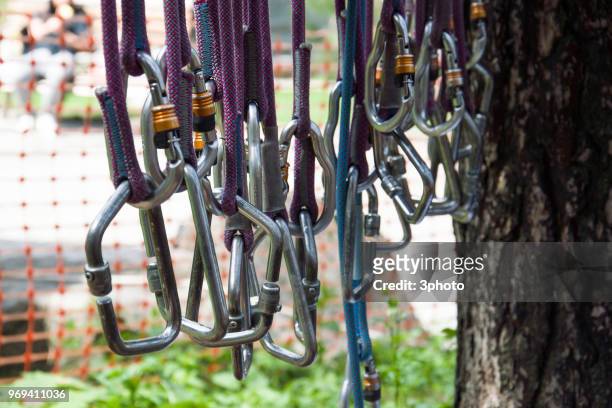 stack of climbing rope carabineers hanging at the playground - carbine foto e immagini stock