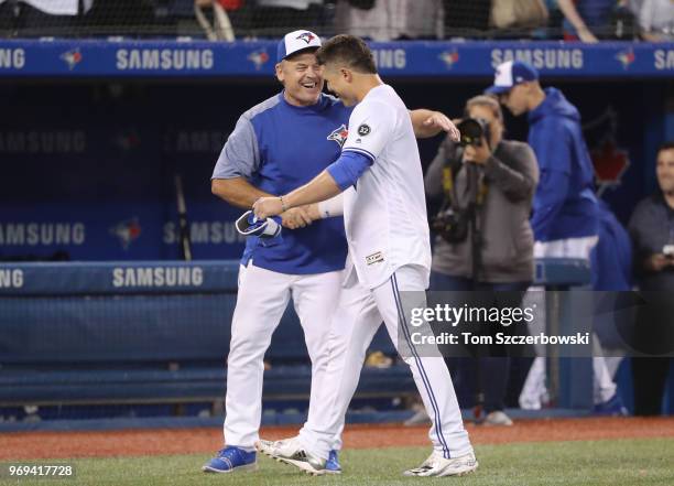 Aledmys Diaz of the Toronto Blue Jays is congratulated by manager John Gibbons after hitting a game-winning RBI single in the tenth inning during MLB...