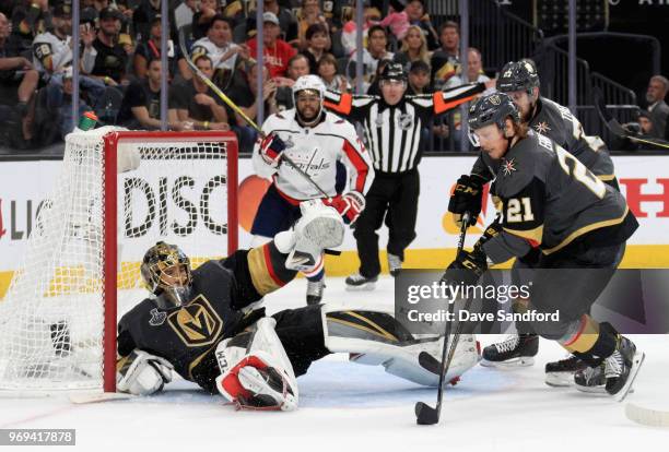 Shea Theodore and Cody Eakin of the Vegas Golden Knights help goaltender Marc-Andre Fleury of the Vegas Golden Knights defend the net during the...