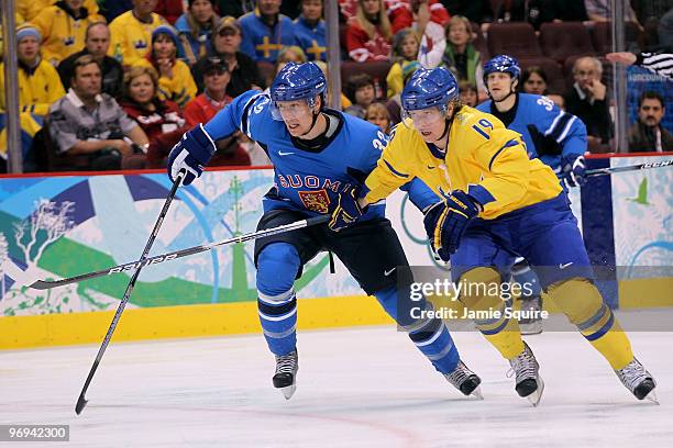 Nicklas Backstrom of Sweden fights for position against Toni Lydman of Finland during the ice hockey men's preliminary game on day 10 of the...