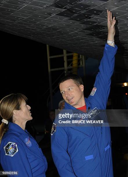 Space shuttle Endeavour STS-130 Pilot Terry Virts speaks with Mission Specialist Kathryn Hire as post flight inspections are conducted after the...
