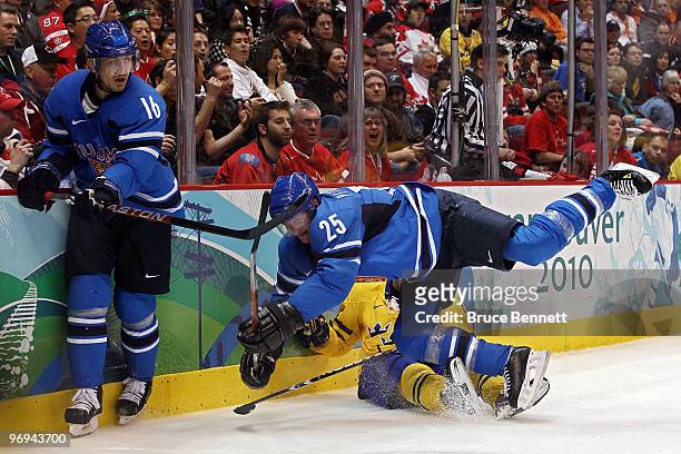 Joni Pitkanen of Finland checks Henrik Sedin of Sweden during the ice hockey men's preliminary game between Sweden and Finland on day 10 of the...