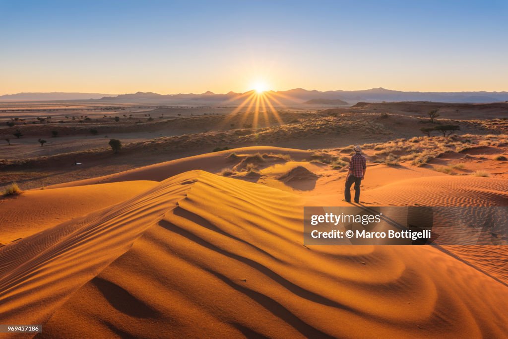 Tourist admiring the sunset over the Namib desert, Namibia