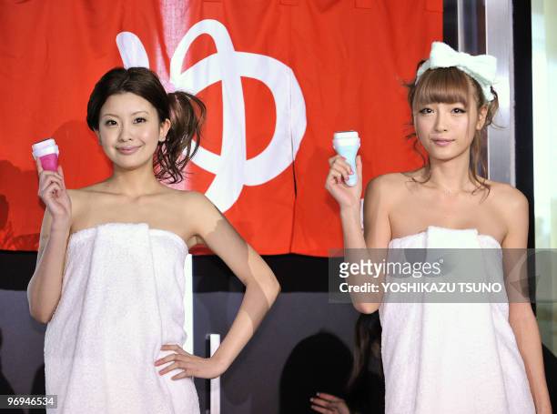 Japanese models Narumi Naka and Yukina Kinoshita, wrapped in bath towels, display the four-blade razor for women called the "Schick Intuition" at a...
