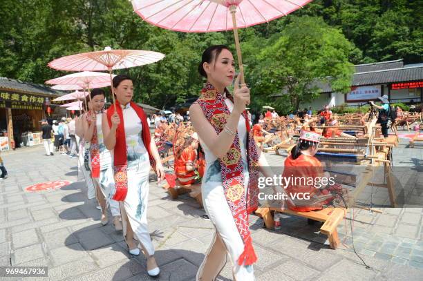 Chinese women of Tujia ethnic group give cheongsam performance to welcome the 13th National Cultural Heritage Day during a show at Zhangjiajie...
