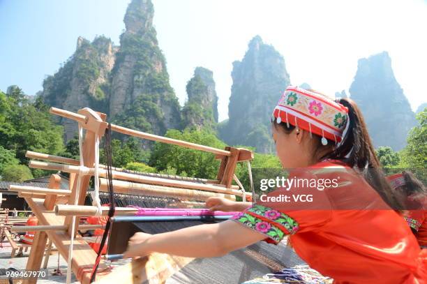 Chinese woman of Tujia ethnic group makes Tujia Brocade, also known as Xilankapu, to welcome the 13th National Cultural Heritage Day during a show at...