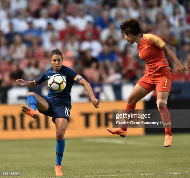 Carli Lloyd of the United States kicks the ball past defender Wang Shuang of China in the second half of an international friendly soccer match at...