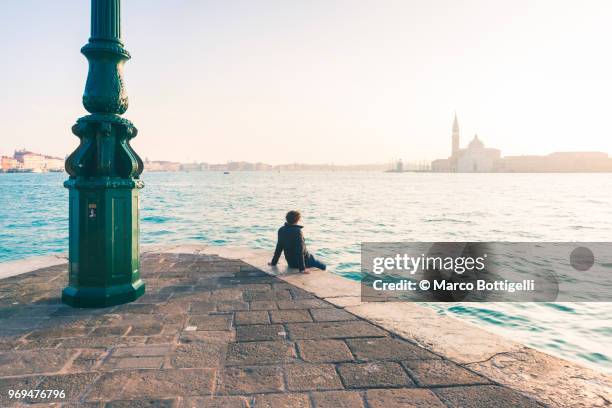 tourist admiring the view in venice, italy - punta della dogana stockfoto's en -beelden