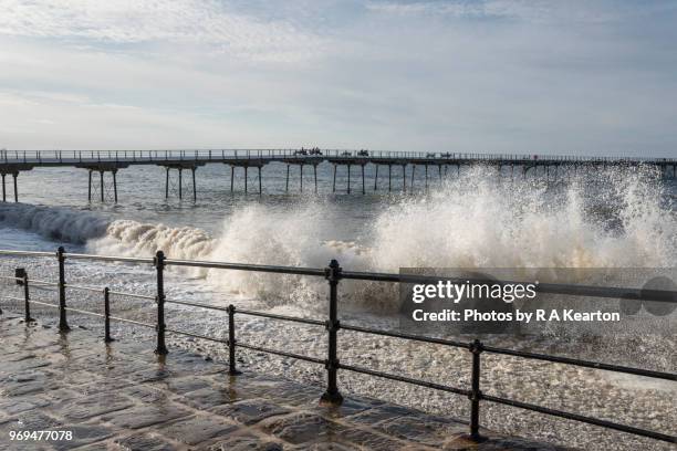 waves crashing against promenade at saltburn-by-the-sea, north yorkshire, england - high tide stock pictures, royalty-free photos & images