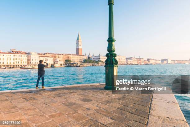 tourist taking a photo with smartphone in venice, italy - punta della dogana stockfoto's en -beelden