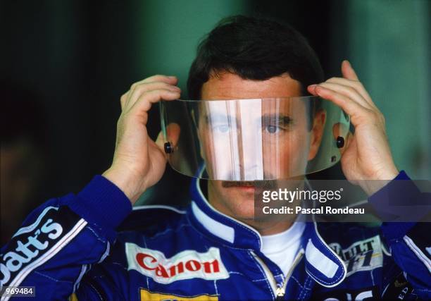Nigel Mansell of Great Britain, driver of the Canon Williams Renault Williams FW14 Renault RS3C V10 looks through his visor before the the Formula...