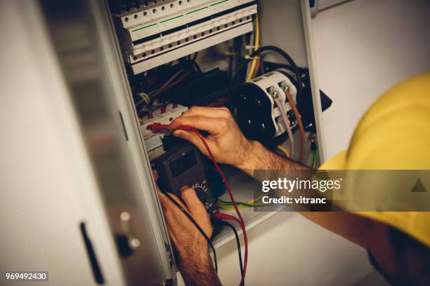 electrician examining fusebox - distribution board stock pictures, royalty-free photos & images