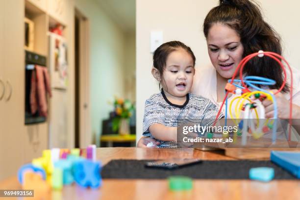 maori moeder met kind thuis spelen. - austraal aziatische volksstammen stockfoto's en -beelden