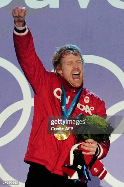 Canada's gold medalist Jon Montgomery celebrates on the podium during the medal ceremony of the men's skeleton final event of the Vancouver Winter...