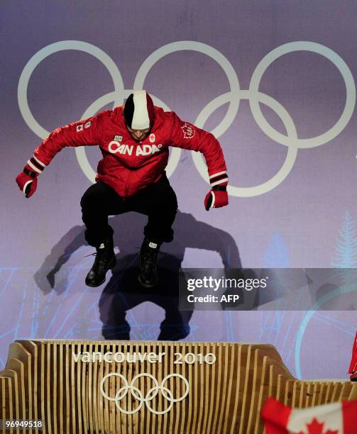 Canada's gold medalist Jon Montgomery jumps on the podium during the medal ceremony of the men's skeleton final event of the Vancouver Winter...