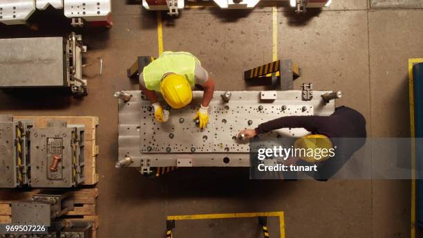 manuel arbeiter in einer produktionslinie teil einer maschine - steel industry stock-fotos und bilder