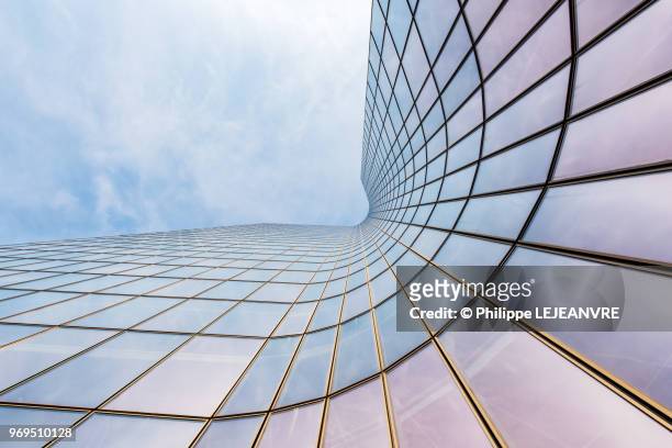 curved skyscraper against blue sky - corporate finance stock-fotos und bilder