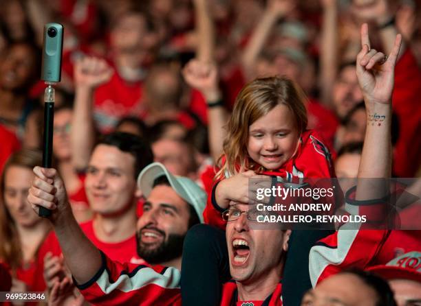 Young girl sits on a man's shoulders as Washington Capitals fans cheer during Game 5 of the Stanley Cup Final against the Vegas Golden Knights at a...