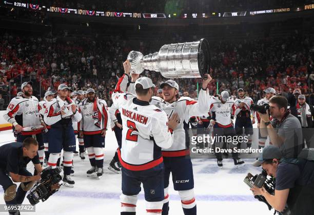 Matt Niskanen of the Washington Capitals passes the Stanley Cup to teammate T.J. Oshie after the Capitals defeated the Vegas Golden Knights 4-3 in...