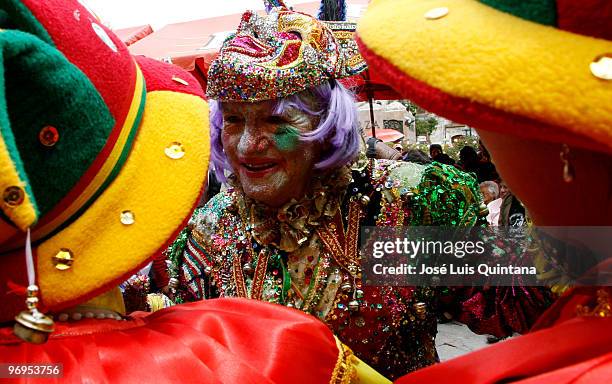 Reveler dressed as Harlequin speaks with Cholitas Pacenas during the celebration of La Muerte del Pepino at the General de La Paz Cemetery on...