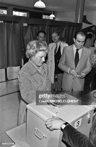Liliane Marchais casts her ballot, while her husband Georges Marchais, leader of the French Communist Party, waits in line at a polling station of...