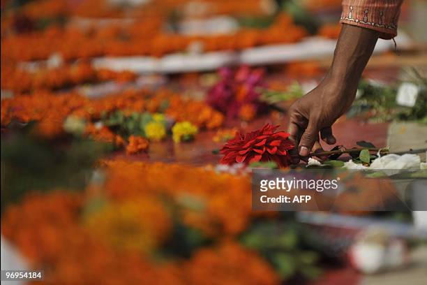 Bangladeshi youth decorates the monument for Bangladesh's Language Movement martyrs with flowers in Dhaka on February 21 to pay homage to the martyrs...