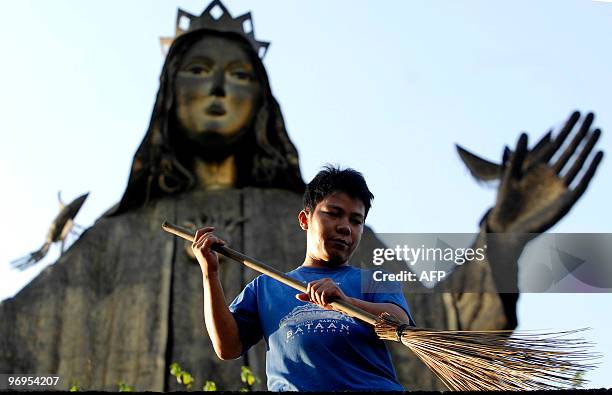 Worker cleans a surrounding area of the EDSA shrine monument in Pasig, east of Manila on February 21, 2010. February 22, 2010 will mark the 24th...