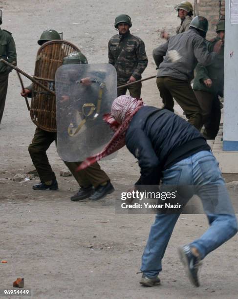 Kashmiri protester throws stones towards Indian policemen during a protest against arrested youths on February 22, 2010 in Srinagar the summer...