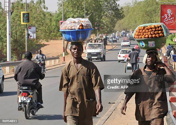 Street vendors walk down a street on February 22, 2010 in Niamey few days after a military coup that overthrew Niger's president Mamadou Tandja. The...