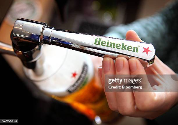 Barperson pours a pint of Heineken beer, brewed by Heineken NV at a public house in London, U.K., on Monday, Feb. 22, 2010. Heineken NV's U.S.-traded...