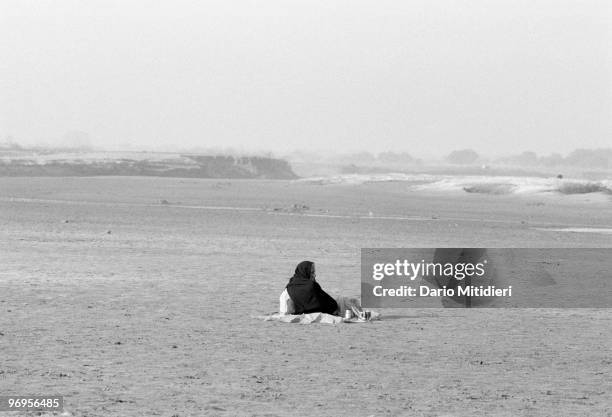 Widow sitting alone on the banks of river Ganges in Vrindavan, India, 1989. Ostracized by society, thousands of India's widows flock to the holy city...