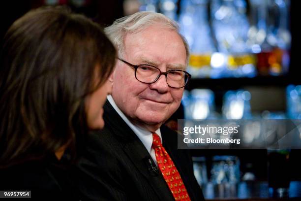 Warren Buffett, chief executive officer of Berkshire Hathaway, listens during a television interview in advance of a charity lunch with a group led...