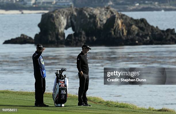 Dustin Johnson looks at the ocean as he waits to hit on he 18th hole during the first round of the AT&T Pebble Beach National Pro-Am at Pebble Beach...