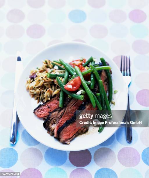 grilled butterflied leg of lamb with green-bean feta salad and toasted orzo - side salad - fotografias e filmes do acervo