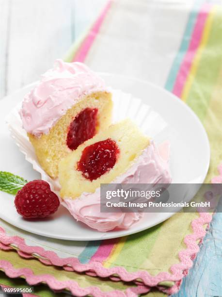 vanilla cupcake with raspberry jam center and pink frosting - dedo mindinho imagens e fotografias de stock