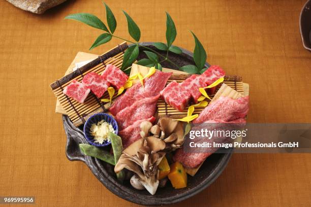 raw wagyu beef on a bamboo mat with oyster mushrooms (japan) - zushi kanagawa stock pictures, royalty-free photos & images