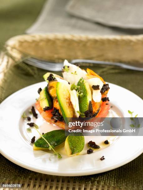 half a tomato with sliced salt-cod,zucchinis and black olives - black cod stock-fotos und bilder