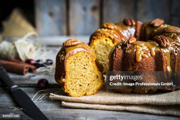 homemade nut cake with a caramel glaze on a wooden surface - whip cream dollop stock pictures, royalty-free photos & images