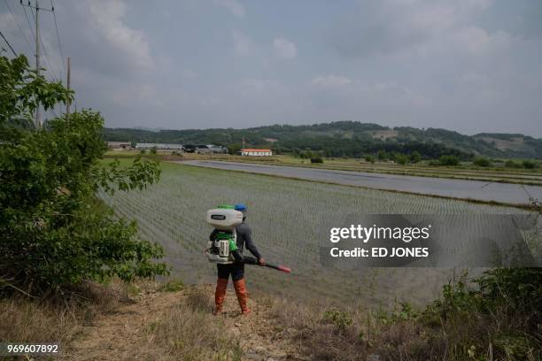 In a photo taken on May 29, 2018 a farmer prepares to fertilize a rice field in Yeoncheon, near the Demilitarized Zone separating North and South...