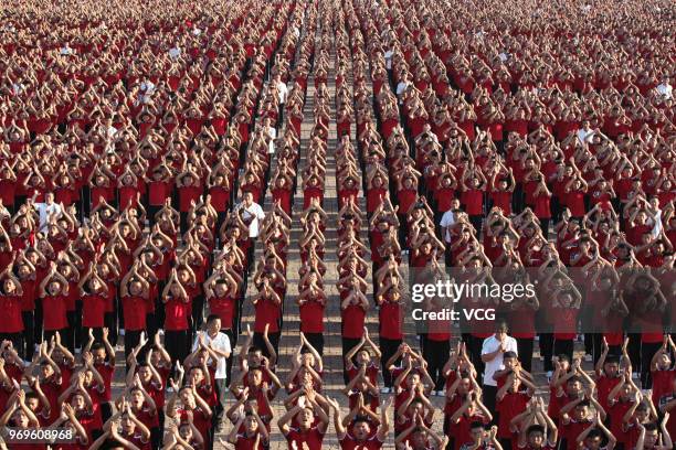 Students of a martial art school perform Shaolin Kung Fu at the foot of Mount Song on June 5, 2018 in Zhengzhou, Henan Province of China. About ten...