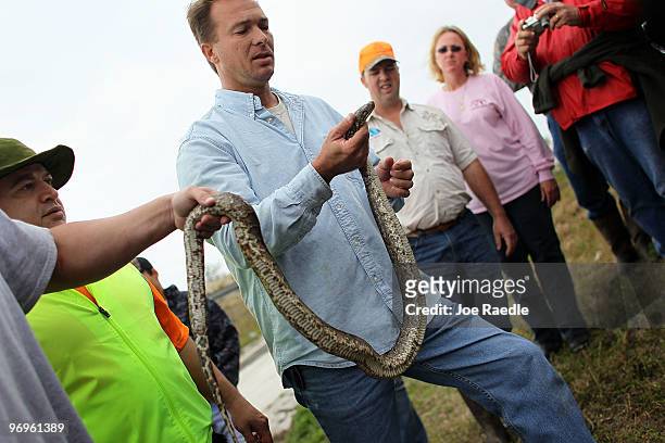 People look on as snake hunter Michael Cole holds a Burmese Python that was captured during a Florida Fish and Wildlife Conservation Commission...