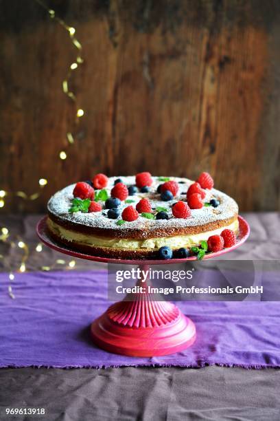 biscuit cake with forest fruits and cream on a stand - soirée mousse stock-fotos und bilder