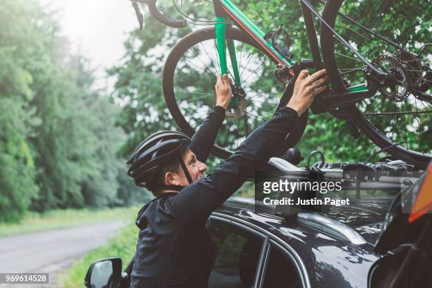 cyclist putting bike on car roof rack - lift roof bildbanksfoton och bilder
