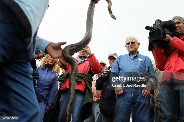 People look on as snake hunter Michael Cole holds a Burmese Python that was captured during a Florida Fish and Wildlife Conservation Commission...