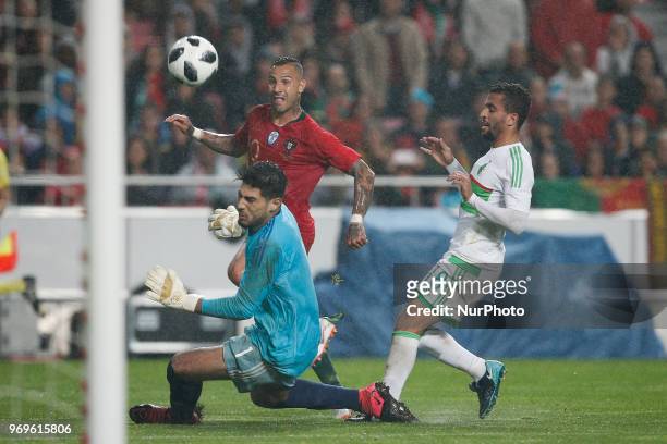 Portugal's midfielder Ricardo Quaresma vies for the ball with Algelia's goalkeeper Abdelkadir Salhi and Algelia's midfielder Mohamed Benkhemassa...