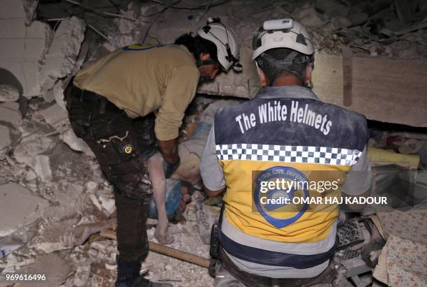 Graphic content / Syrian rescuers, known as White Helmets, recover bodies in Zardana, in the mostly rebel-held northern Syrian Idlib province,...